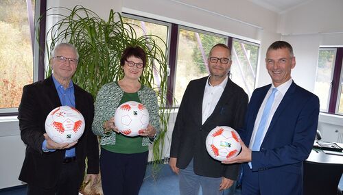 Fußball kann zukünftig mit fair gehandelten Bällen gespielt werden. Von links: Sportkreis-Vorsitzender Manfred Schmidt, Fairtrade-Dezernentin Monika Merkert, Harald Rubel und Landrat Frank Kilian, die die Bälle schon einmal testen. 