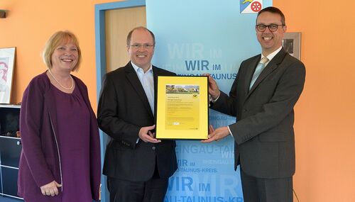 Landrat Albers nimmt das Zertifikat aus den Händen von Hagen Kraus und Susanne Deisel von der Deutschen Post AG entgegen.