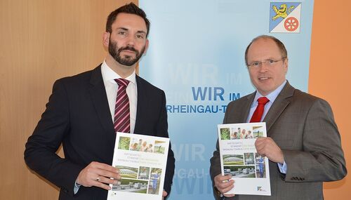 Landrat Burkhard Albers (re.) und der Leiter der Kreiswirtschaftsförderung Ralf Bachmann (li.) präsentieren die brandneue Wirtschaftsbroschüre für den Rheingau-Taunus-Kreis.